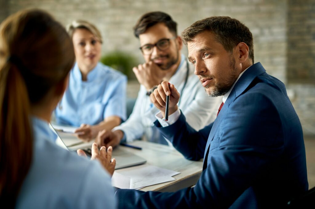 Businessman communicating with team of doctors on a meeting in the office.